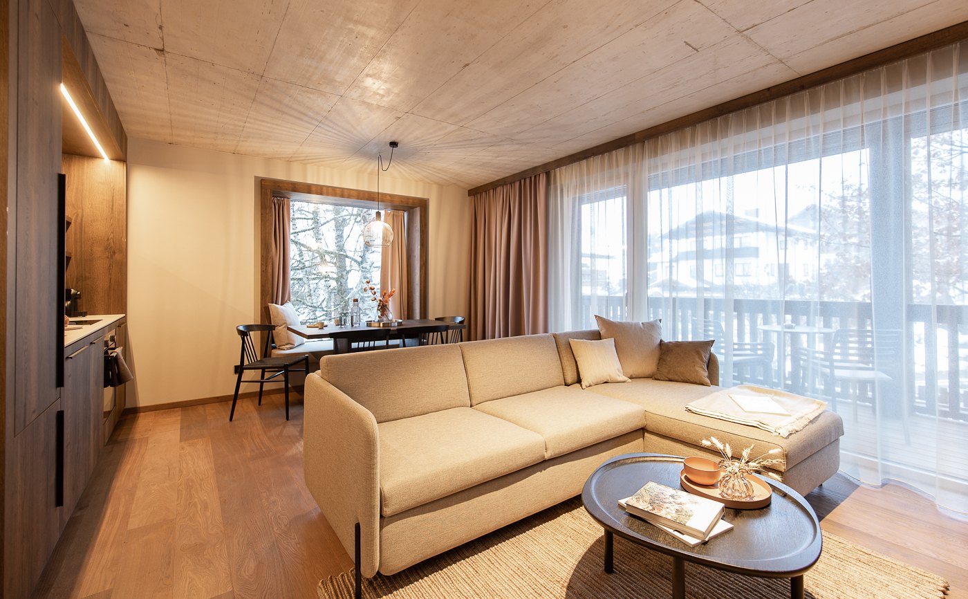 Apartment mit beigem Sofa, Holzflächen und großem Fenster
